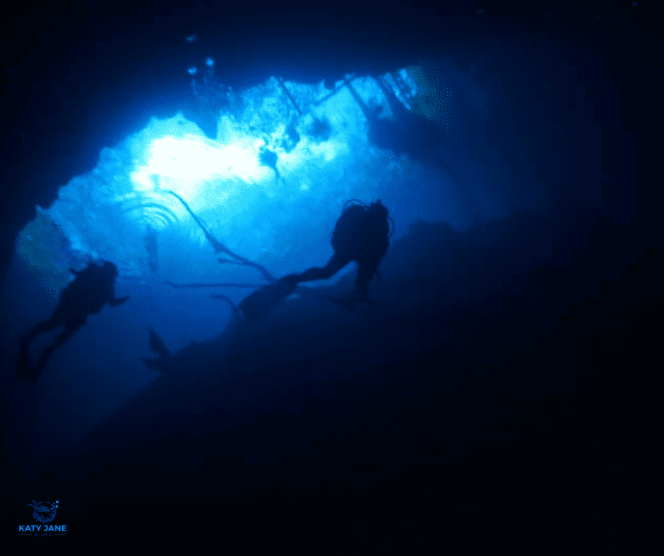 divers underwater with dark blue