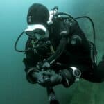 Scuba diver in green water with white mask
