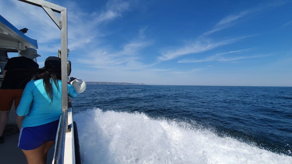 Girl on boat with waves and blue water