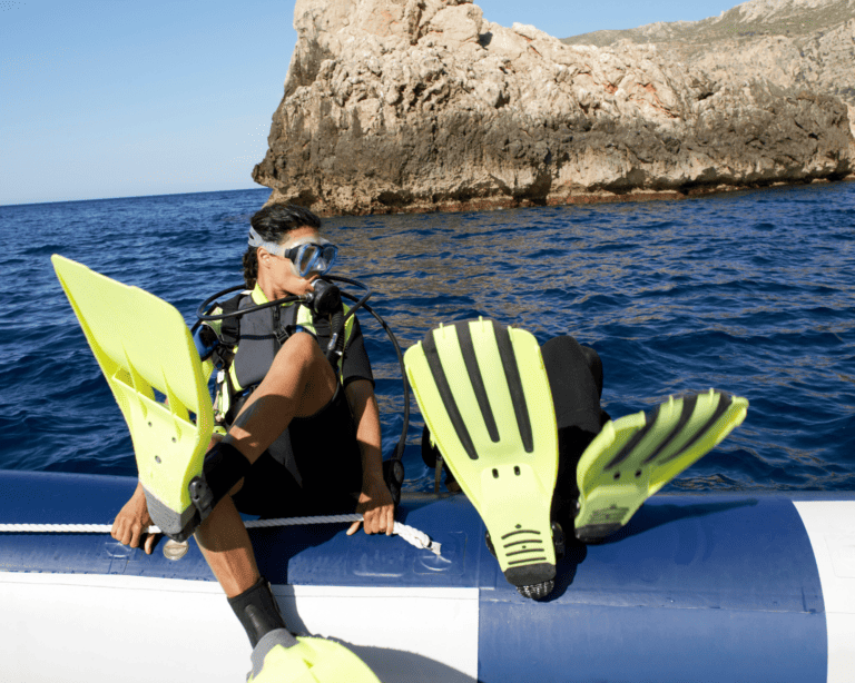 two scuba divers falling backwards off a boat into the sea