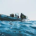 Scuba diver rolling backwards from a boat at sea