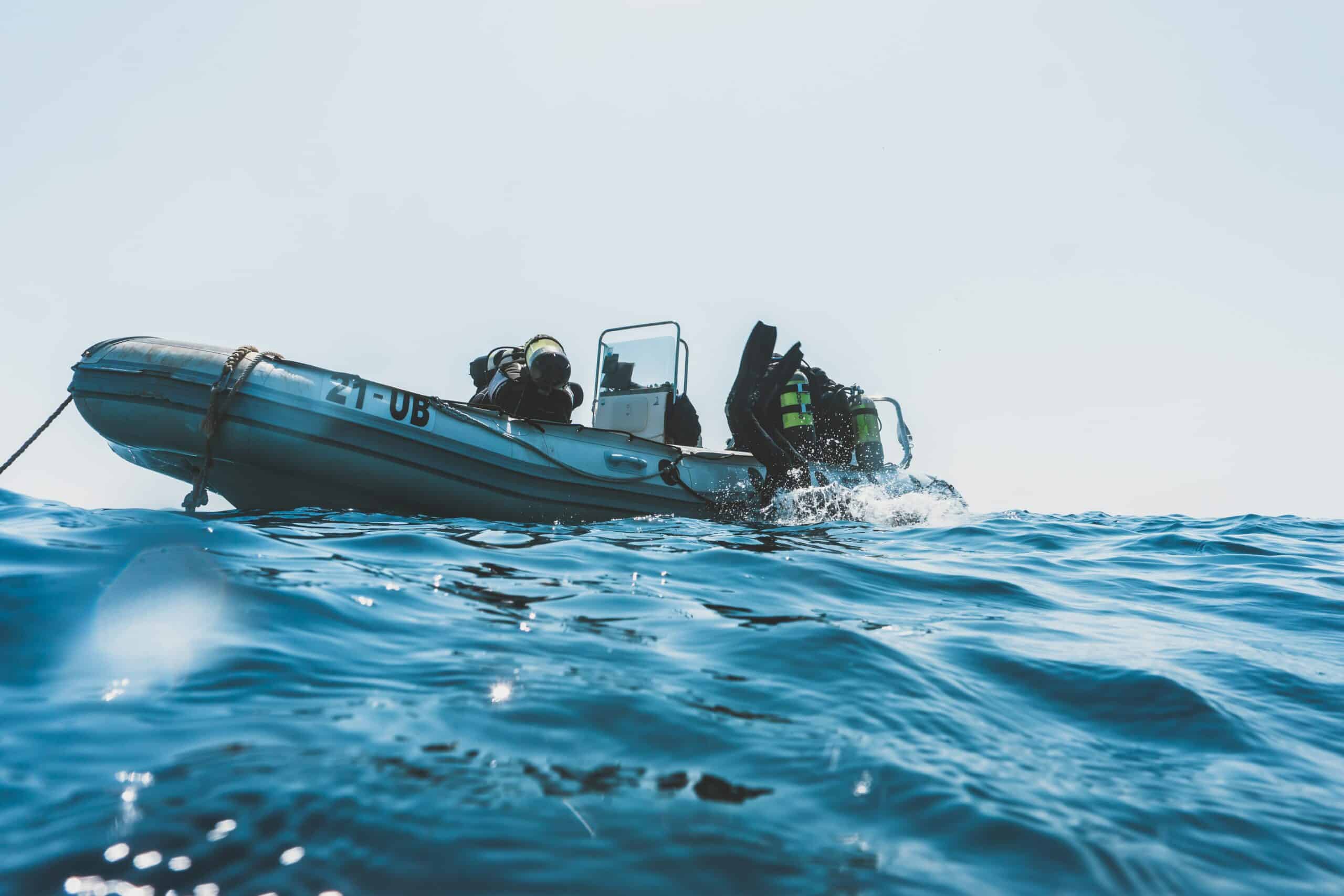 Scuba diver rolling backwards from a boat at sea