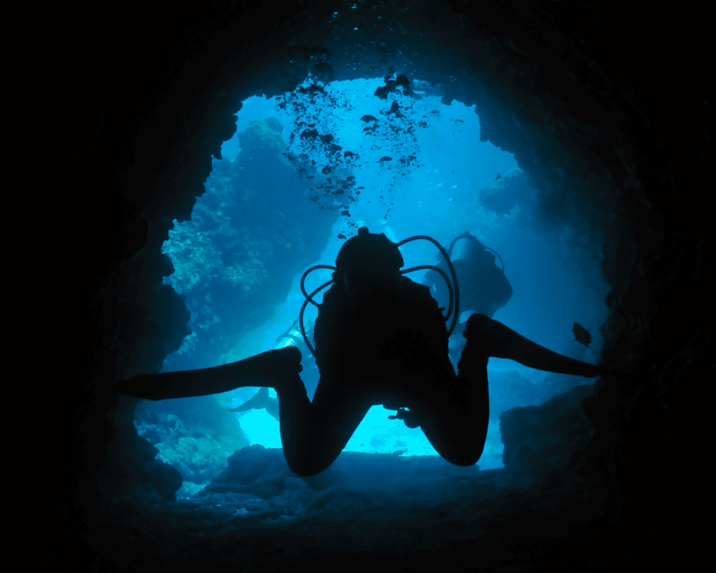 scuba diver neutrally buoyant whilst moving through a swim through