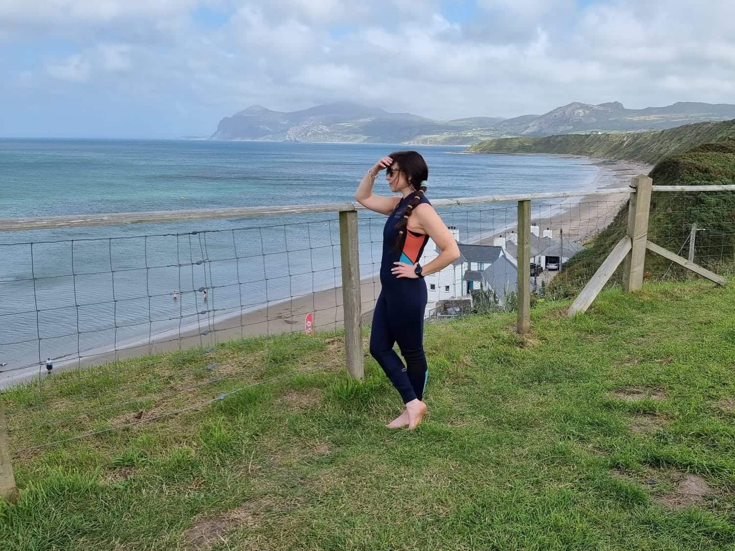 Katy Jane wearing the Osprey Action Sports Long Jane wetsuit by beach