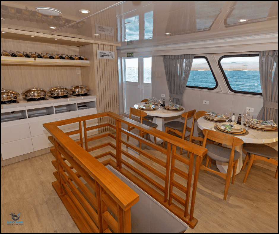 photo of dining area with food saucepans and tables and chairs with windows looking out onto the ocean