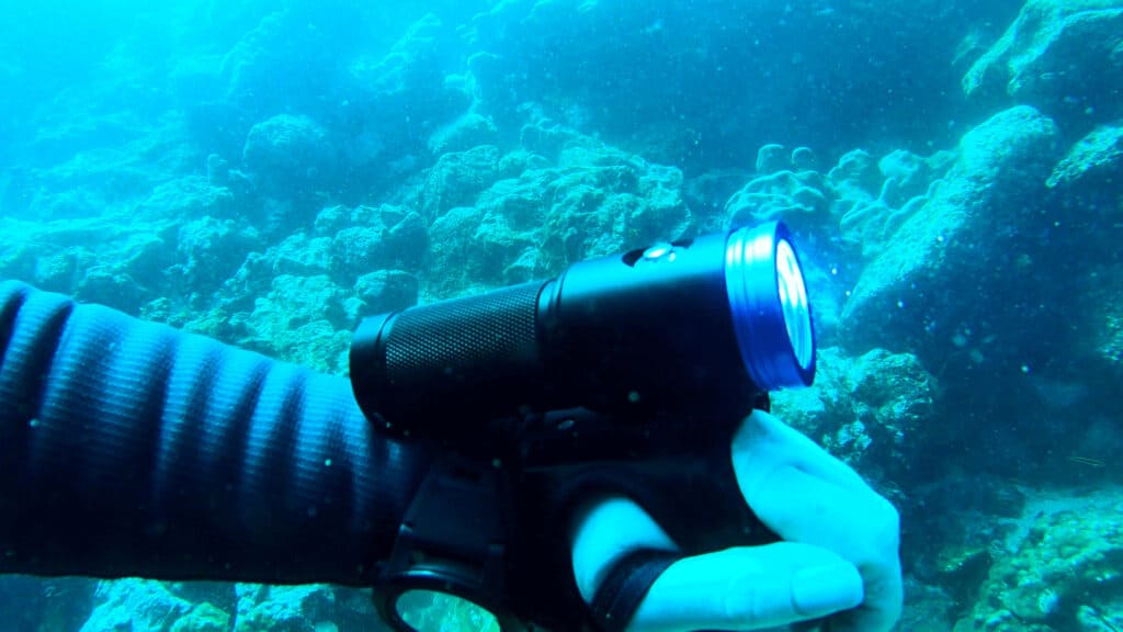 dive torch and light underwater on divers hand