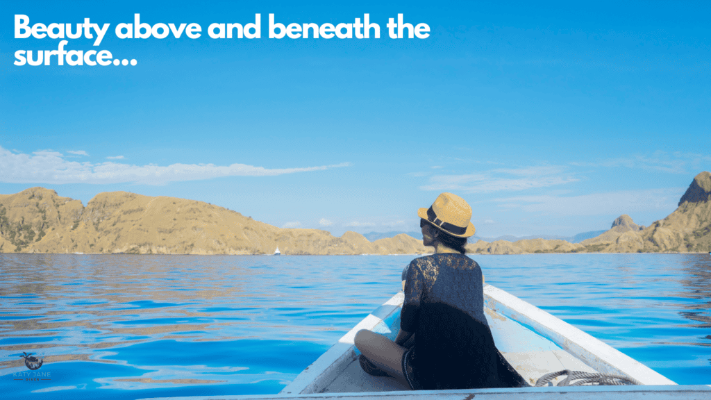 lady sitting on front of boat on calm water looking out to a rocky island ahead with blue skies