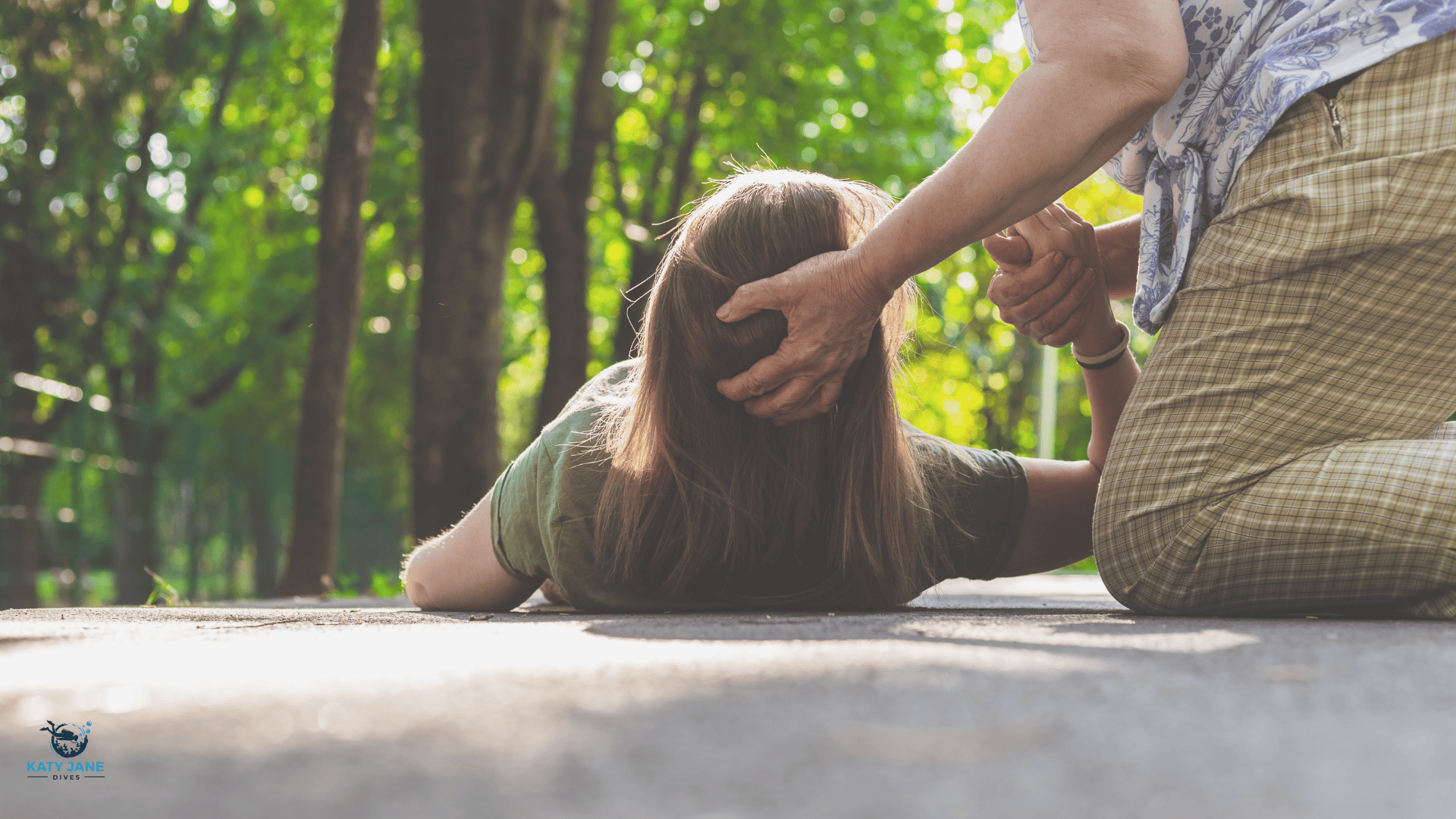 woman lying on floor with epilepsy and persons hand protecting head from floor