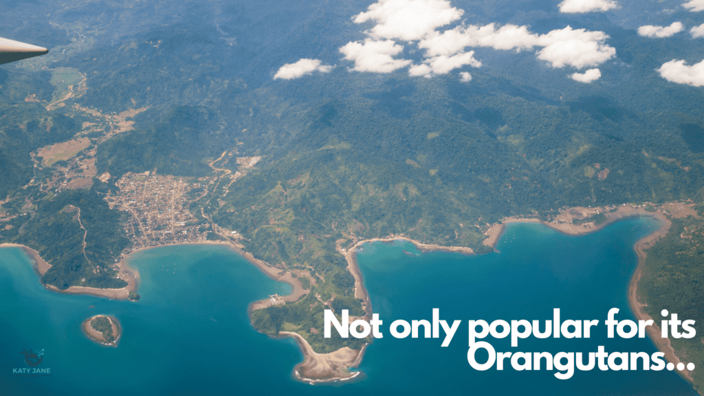 arial photo taken from plane of blue water and coastline with hills and trees and small villages